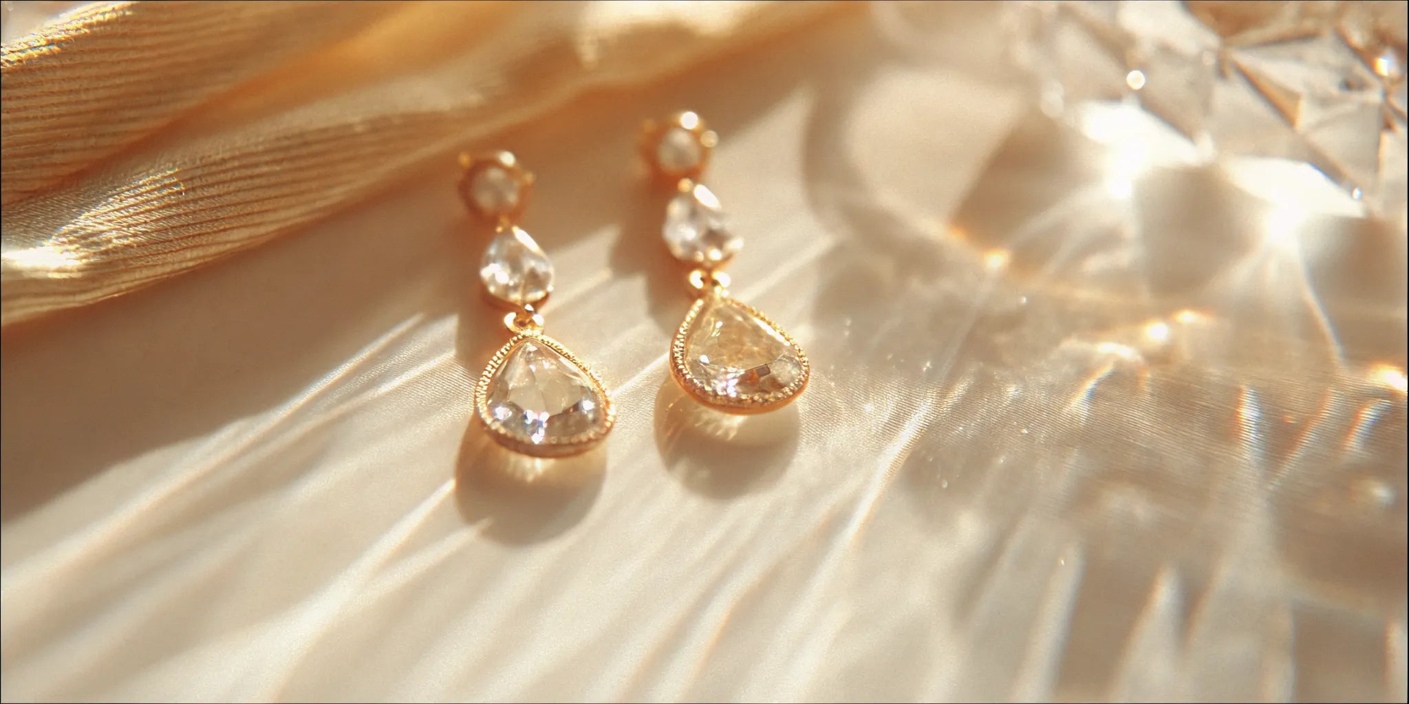 Classic gold pear drop earrings with clear gemstones.