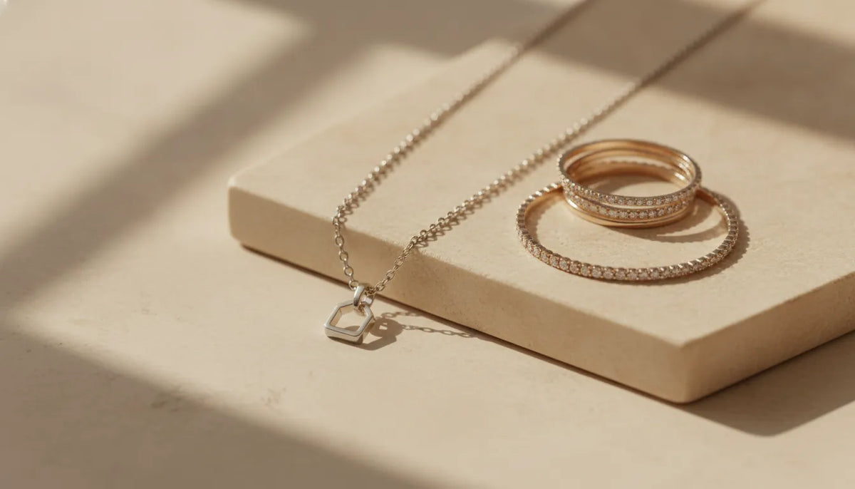 Platinum jewelry arranged on a warm ivory surface in soft studio light