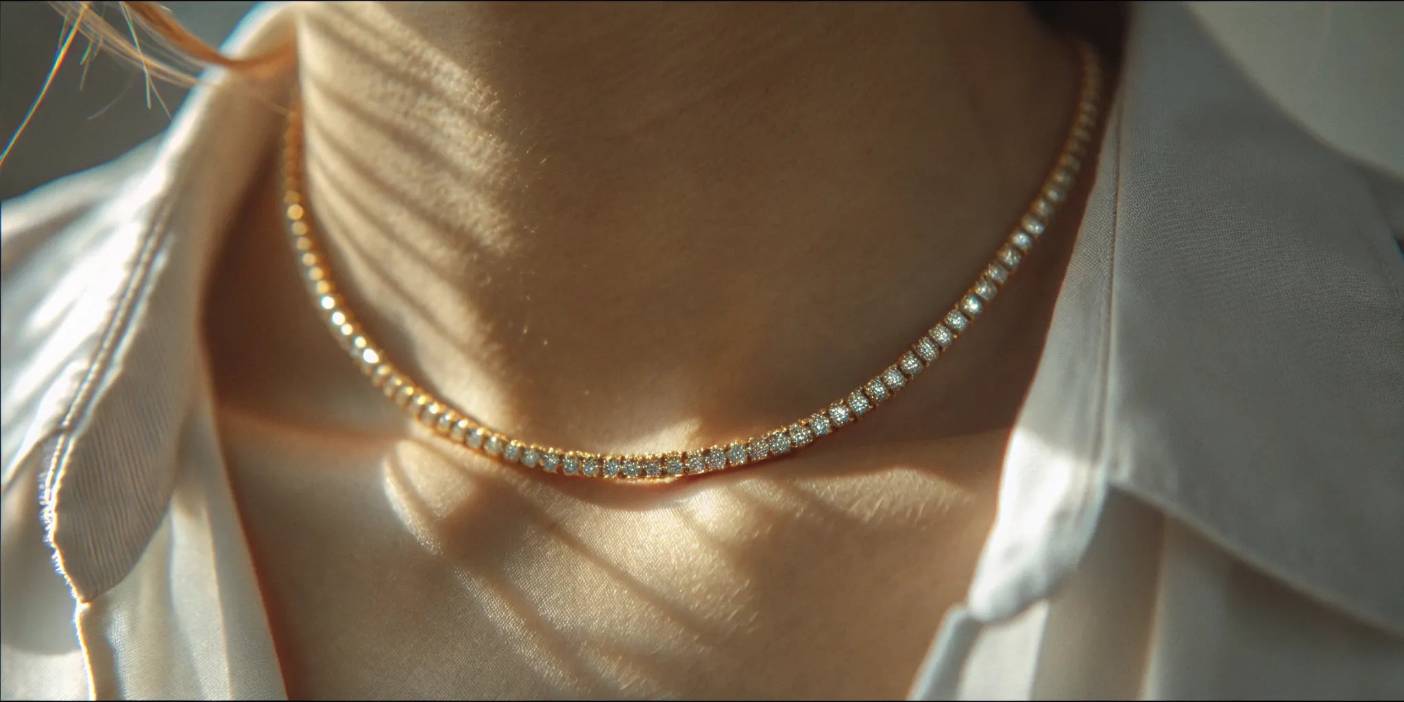 A 14k gold diamond tennis choker sparkling on a woman's neck.