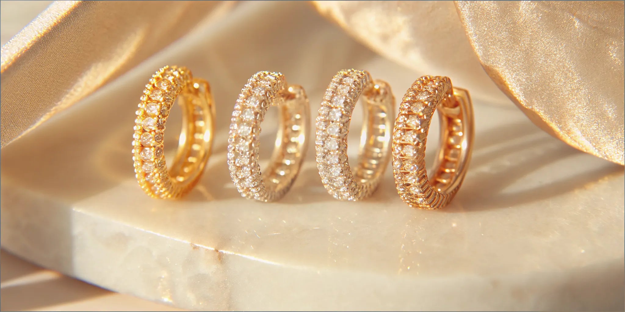 Pave huggie earrings in gold and silver with sparkling stones.