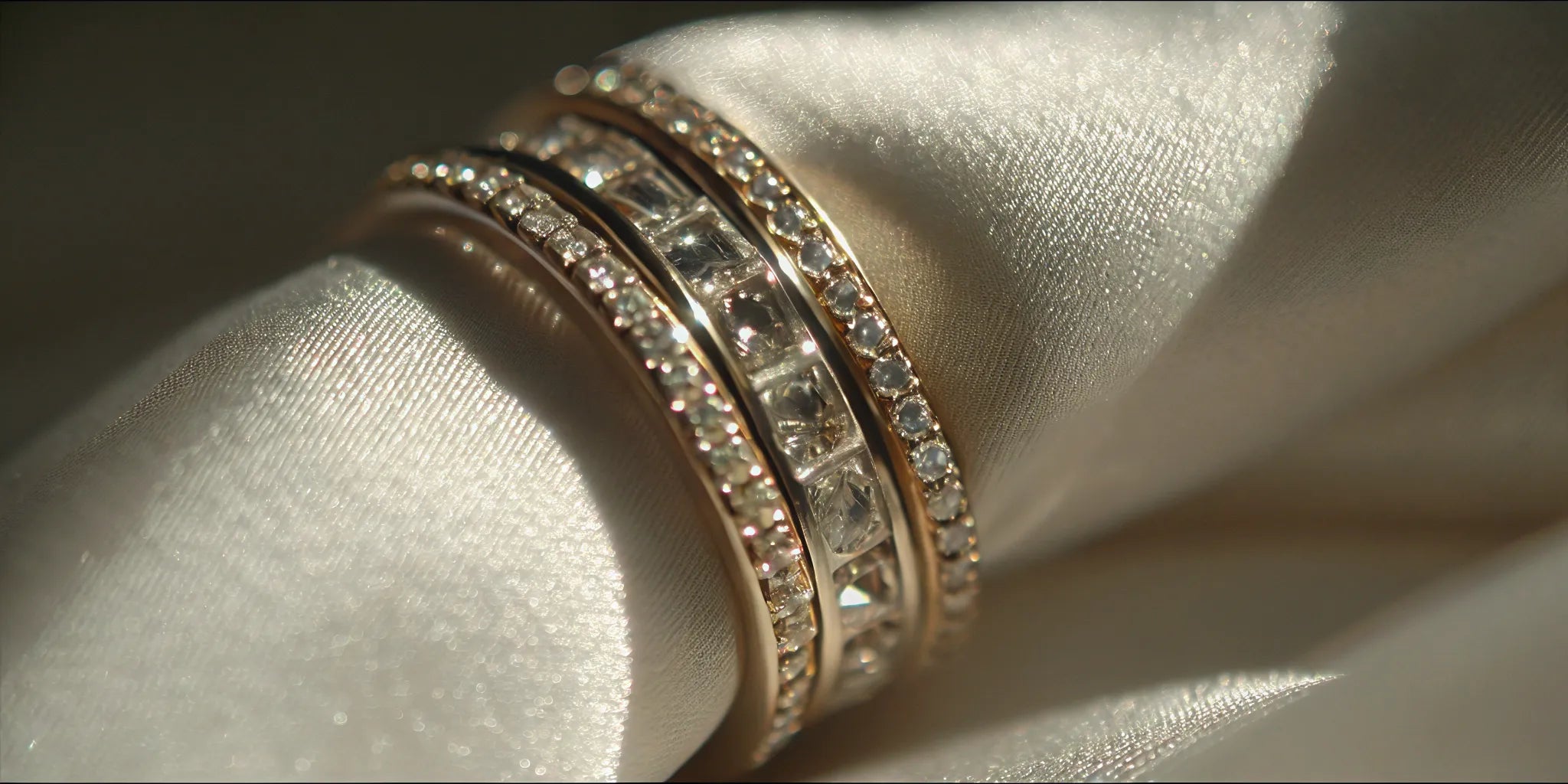 A stack of white gold diamond rings featuring various pavé, textured, and minimalist bands.