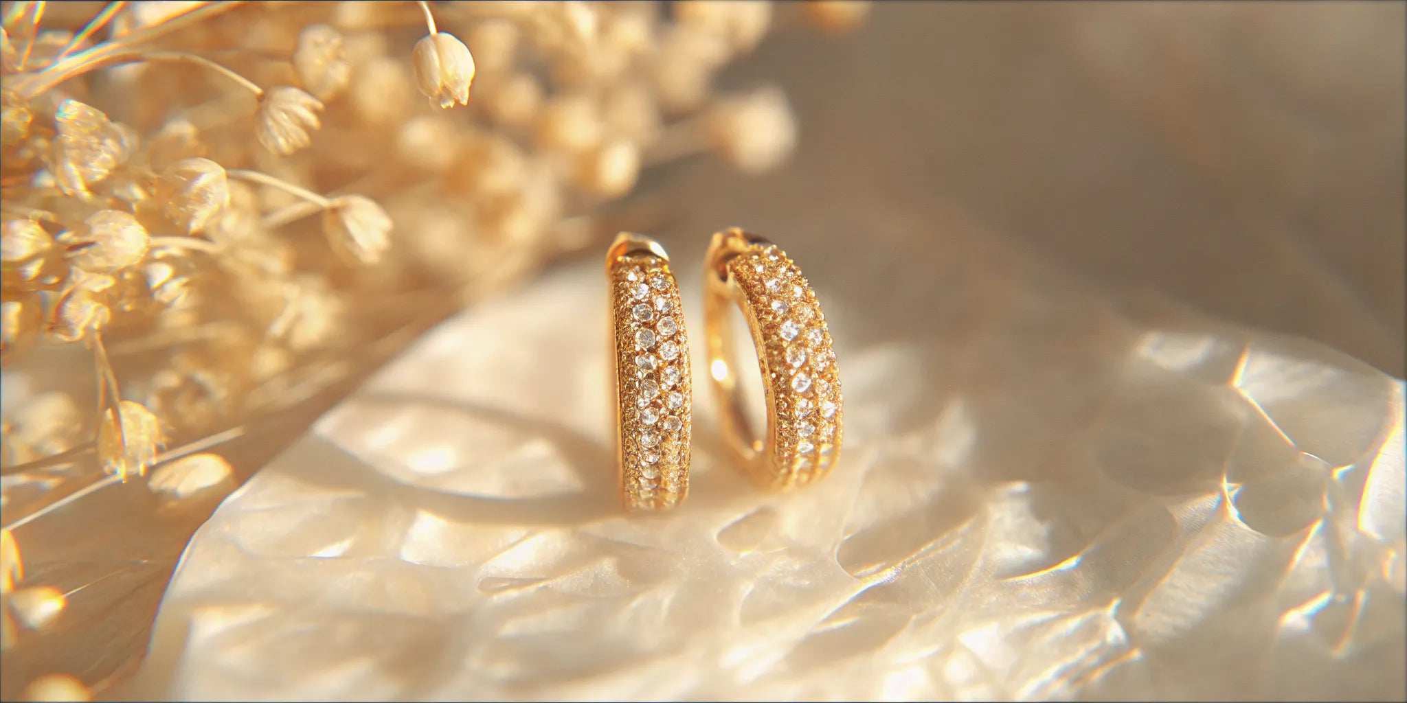 Petite infinity huggie earrings in 18k gold with pavé diamonds.
