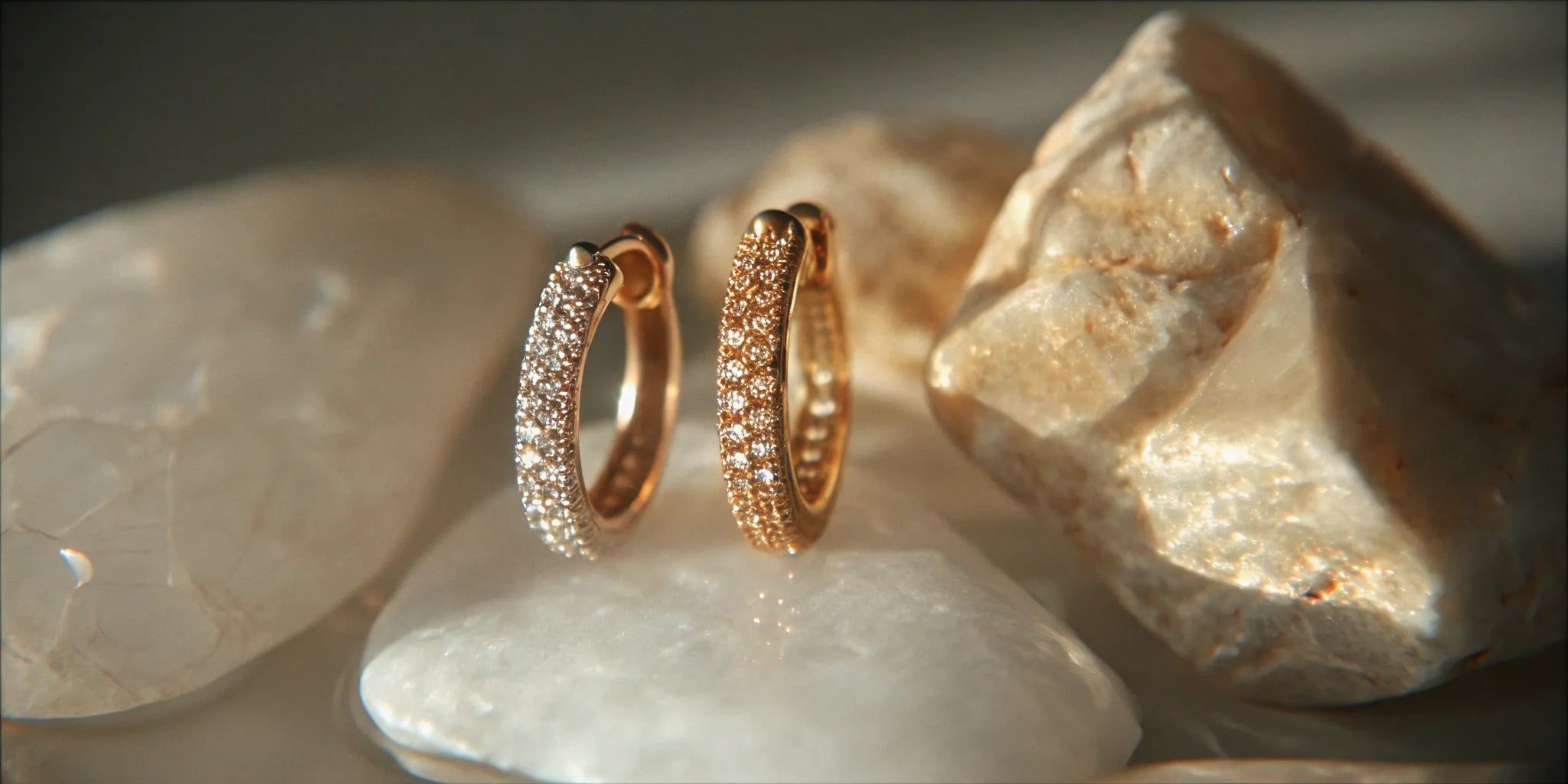 Gold micro pavé huggie earrings with sparkling diamonds.