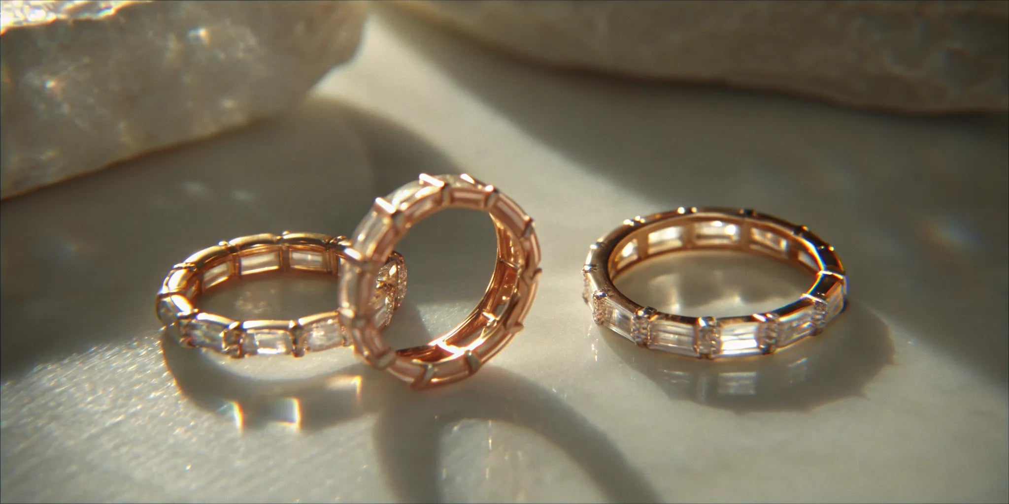 Three different styles of gold eternity wedding rings stacked together.