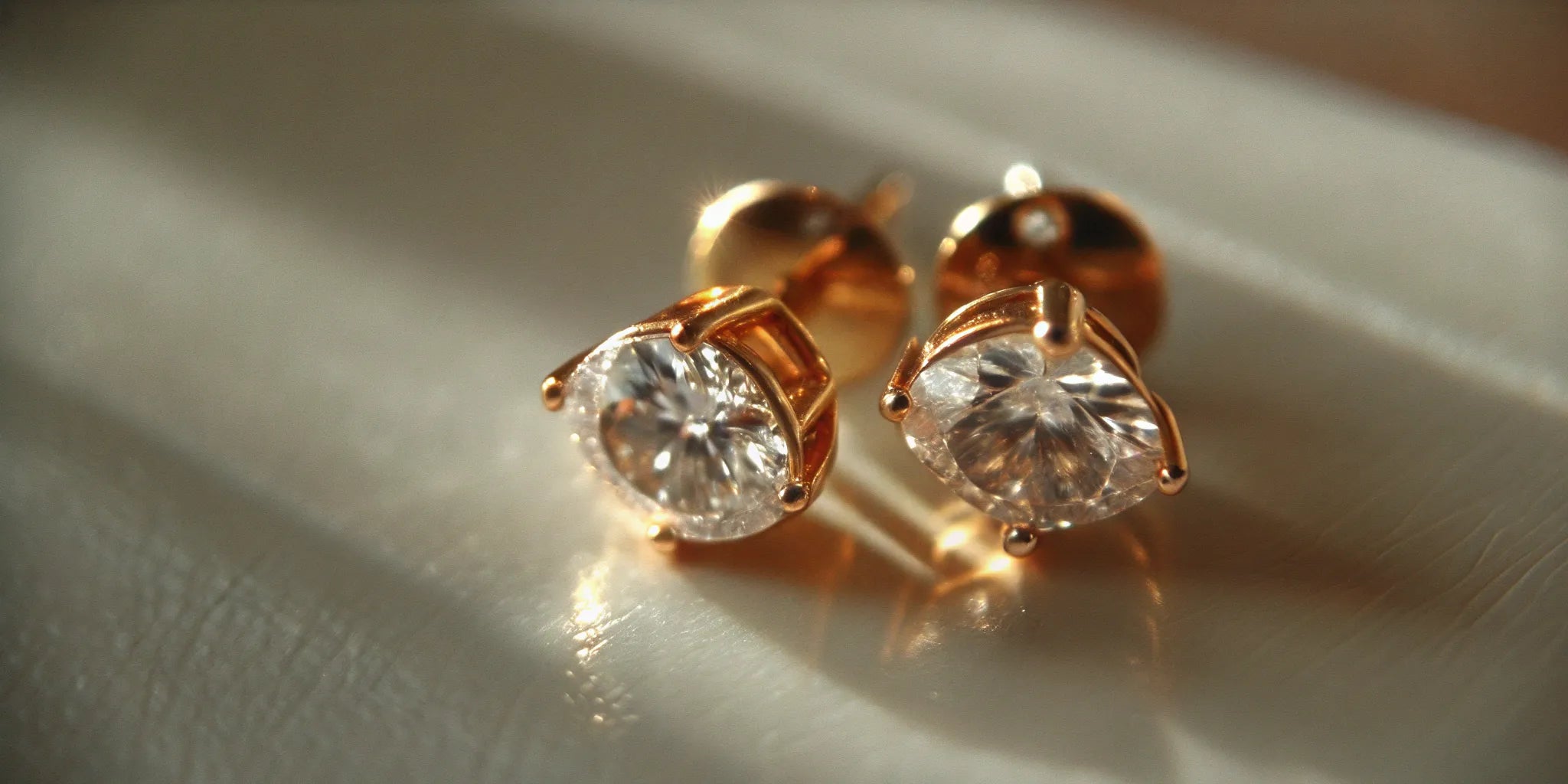 A pair of pear shaped diamond studs in yellow gold.