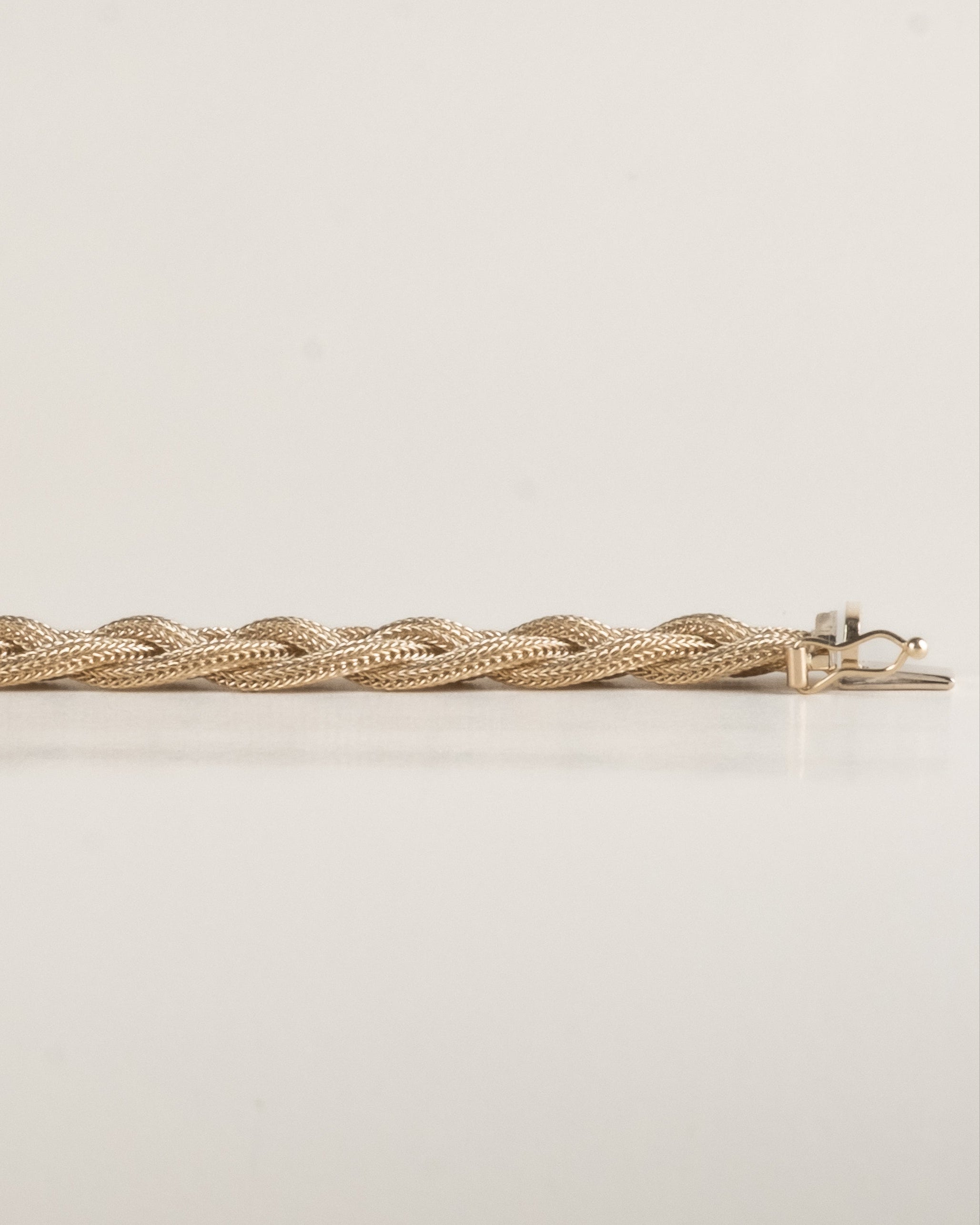 Gold braided bracelet, laid out